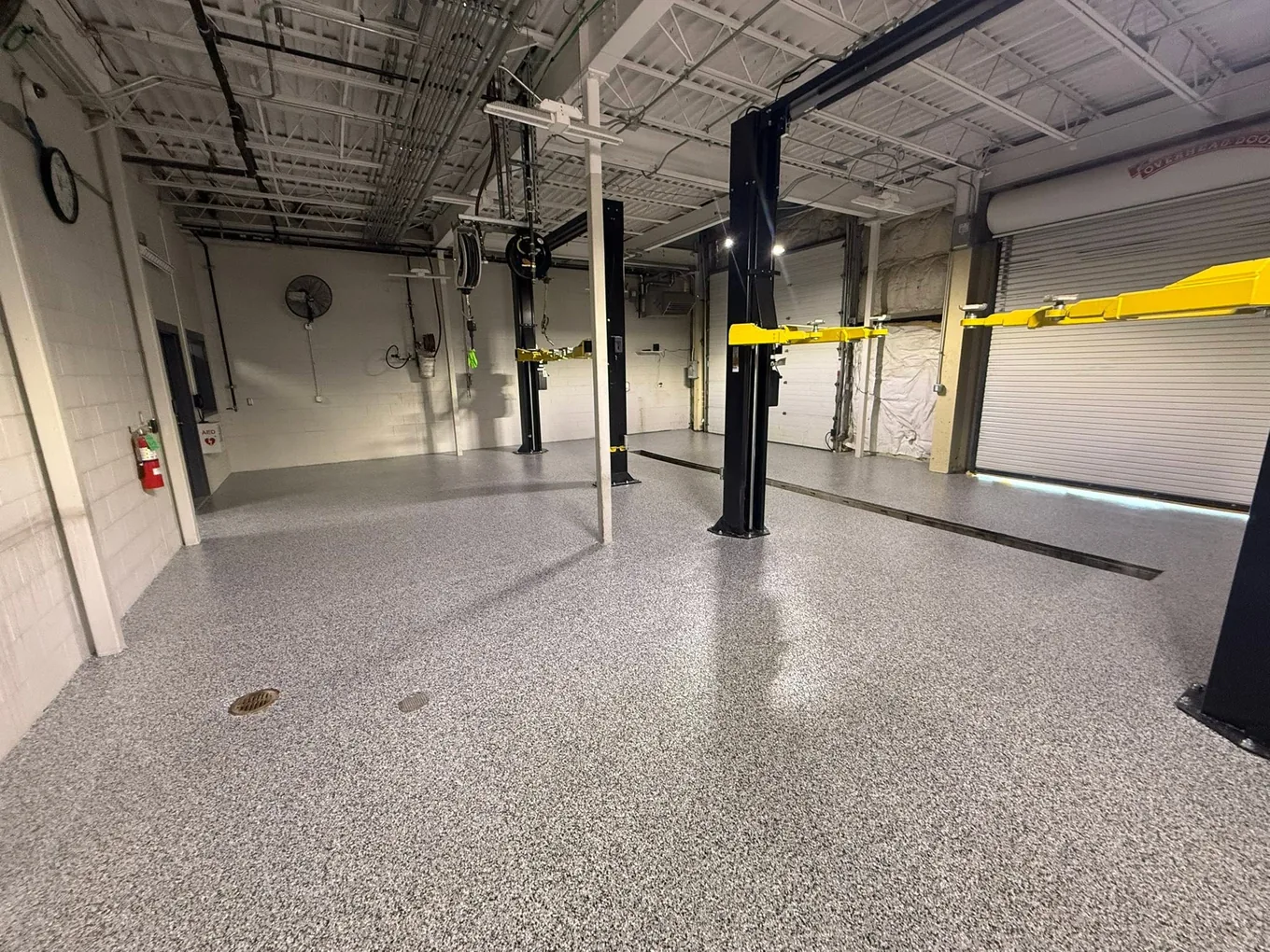 Coated shop floor running between two vehicle lifts in a service bay