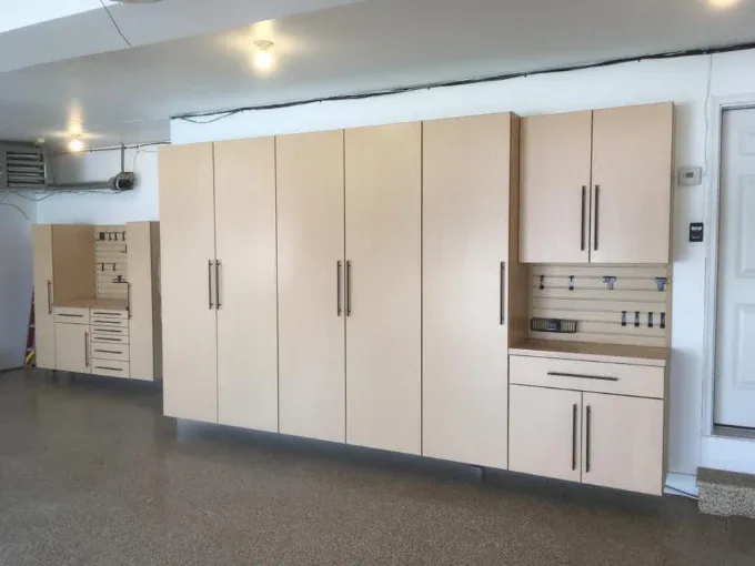 Cream garage cabinets running the length of a coated garage wall