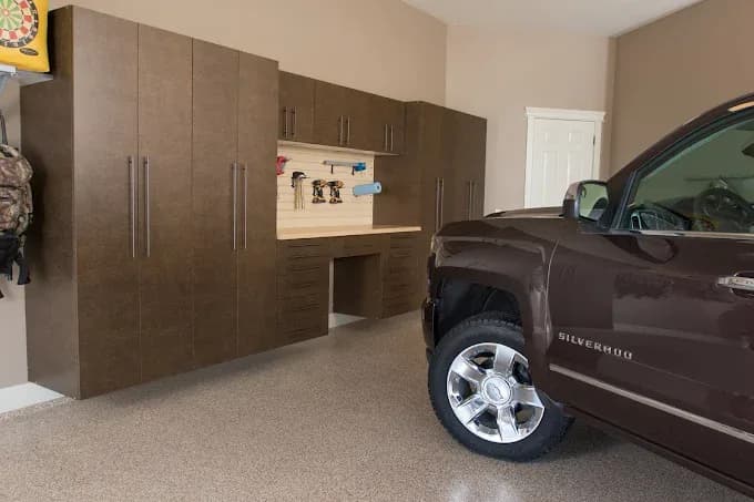 Dark wood-tone garage cabinet wall next to a parked pickup truck
