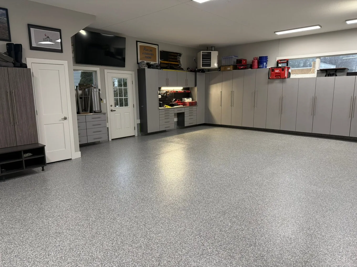 Finished home garage with a gray flake floor and full-wall cabinets