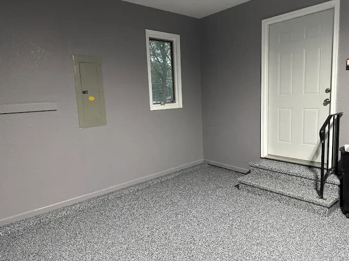 Gray flake floor coating in a finished garage with painted walls