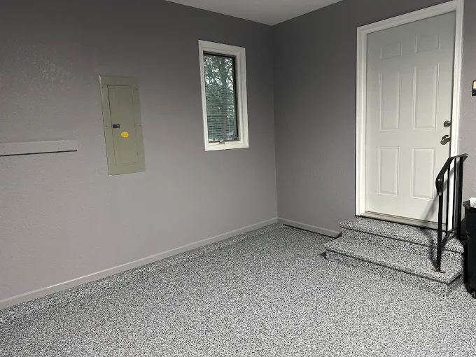Gray flake floor coating in a finished garage with painted walls