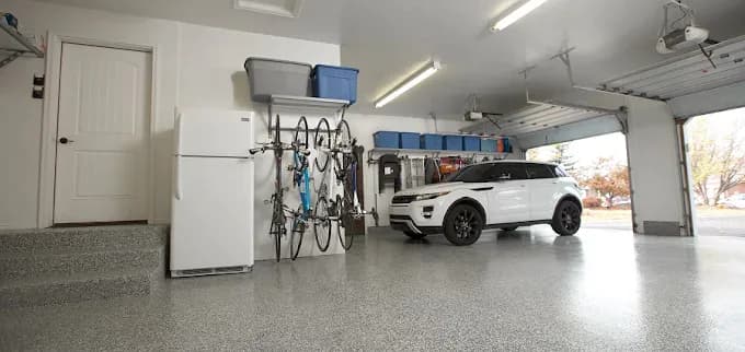 Coated garage floor with bikes on the wall and an SUV parked inside