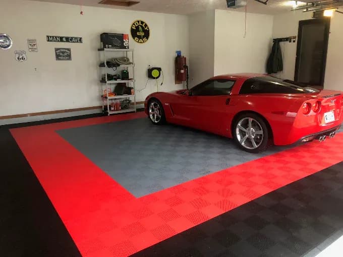 Red and gray modular tile floor under a red Corvette